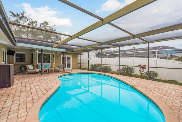 view of pool featuring cooling unit, an outdoor hangout area, glass enclosure, and a patio