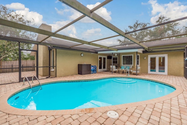 view of swimming pool with a lanai, a patio, and french doors