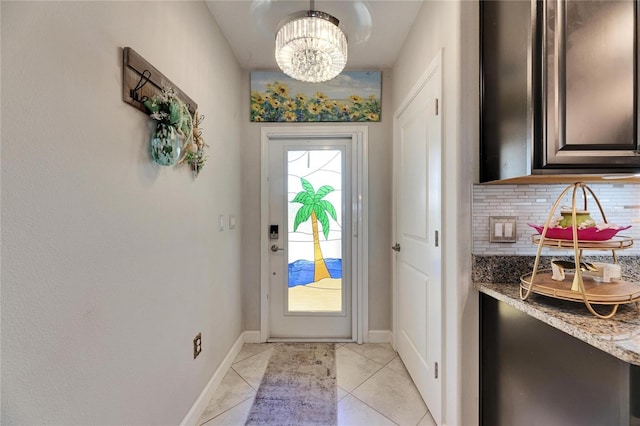 doorway to outside with a notable chandelier and light tile patterned floors