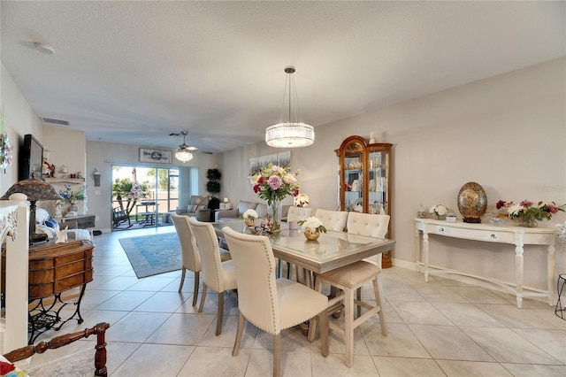 tiled dining room with a textured ceiling and ceiling fan