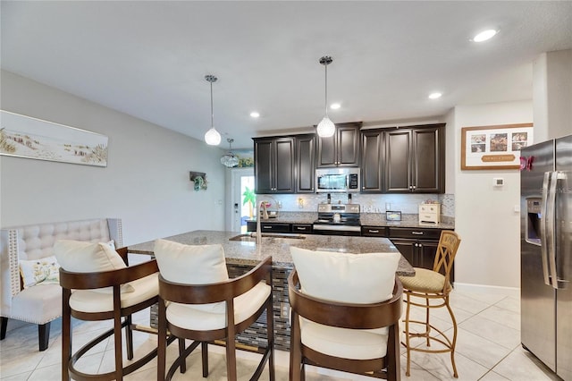 kitchen with stainless steel appliances, light tile patterned floors, pendant lighting, and sink