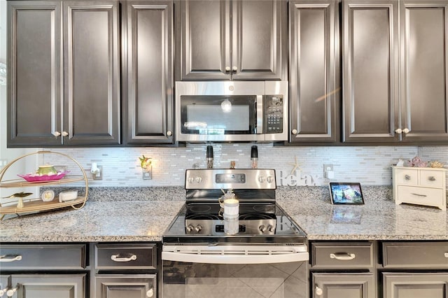 kitchen with stainless steel appliances, backsplash, and light stone countertops