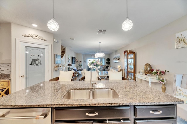 kitchen featuring a center island with sink, pendant lighting, and sink