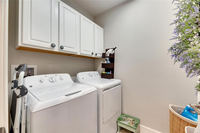 washroom with washer and dryer and cabinets