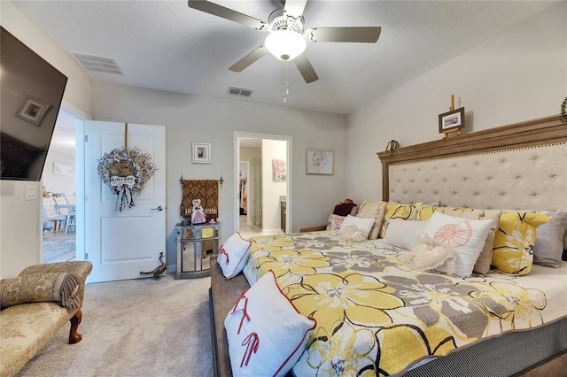 carpeted bedroom with ceiling fan and a textured ceiling