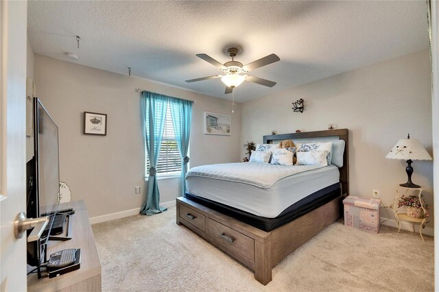 carpeted bedroom with a textured ceiling and ceiling fan