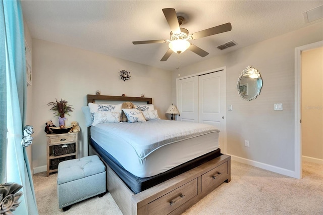 carpeted bedroom with ceiling fan and a closet