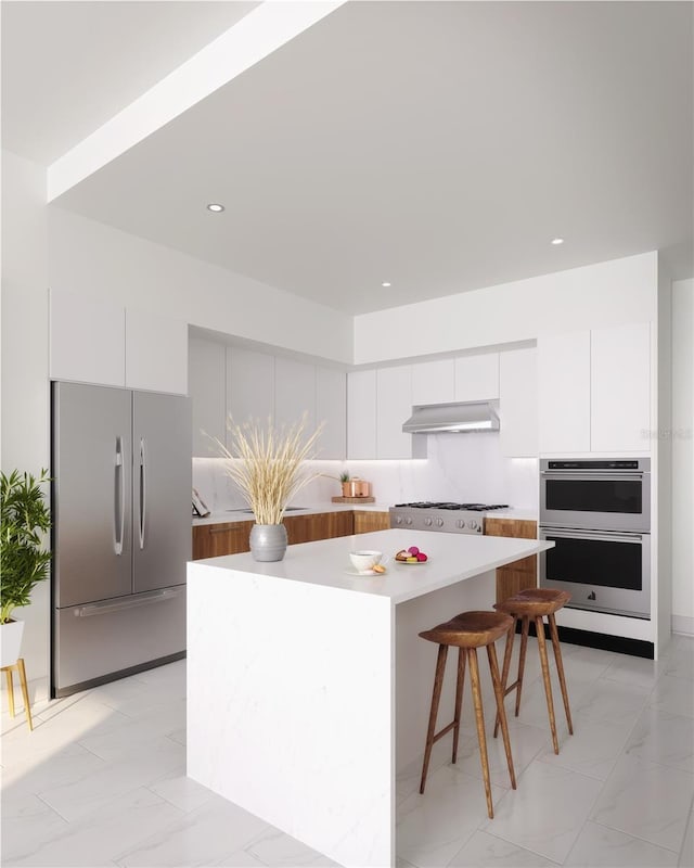 kitchen with white cabinetry, stainless steel appliances, a breakfast bar, and a kitchen island