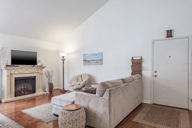 living room featuring vaulted ceiling, a high end fireplace, and wood-type flooring