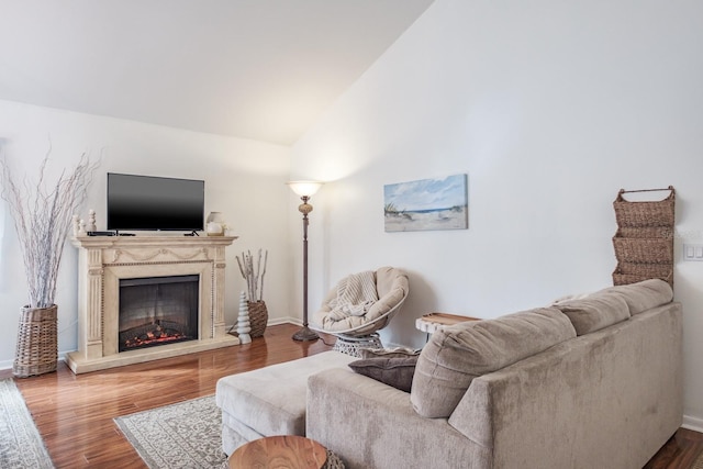 living room with vaulted ceiling, a premium fireplace, and hardwood / wood-style floors