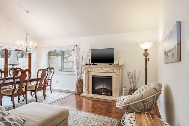 living room featuring a chandelier, lofted ceiling, and hardwood / wood-style flooring