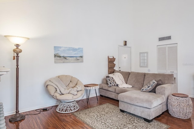 living room featuring a high ceiling and hardwood / wood-style floors