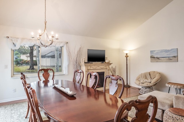 dining area featuring vaulted ceiling, an inviting chandelier, and hardwood / wood-style floors