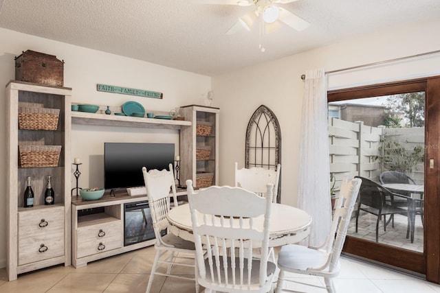 tiled dining area featuring a textured ceiling and ceiling fan