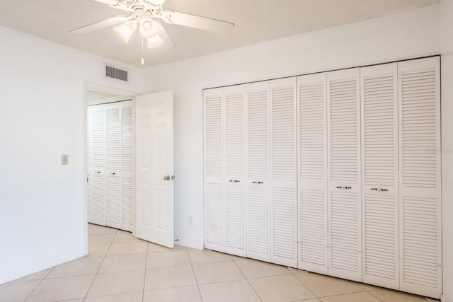 unfurnished bedroom featuring ceiling fan and light tile patterned floors