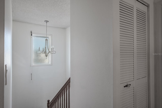 details featuring an inviting chandelier and a textured ceiling