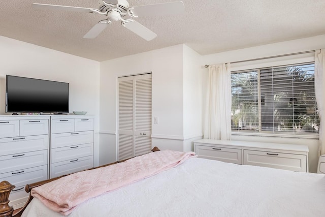 bedroom with a textured ceiling, ceiling fan, and a closet