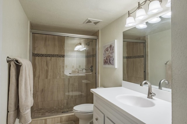 bathroom with toilet, vanity, and an enclosed shower