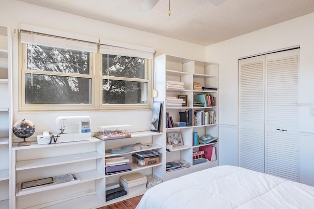 bedroom featuring ceiling fan, a textured ceiling, hardwood / wood-style flooring, and a closet