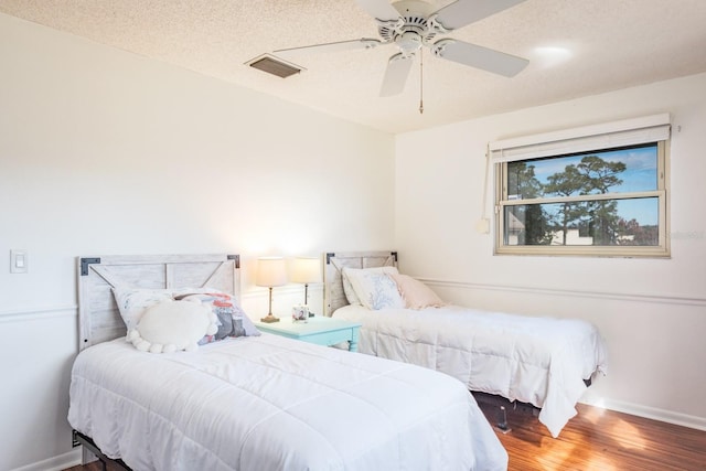 bedroom with ceiling fan, a textured ceiling, and hardwood / wood-style flooring