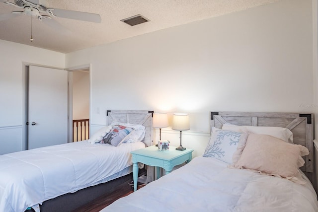 bedroom with ceiling fan and a textured ceiling