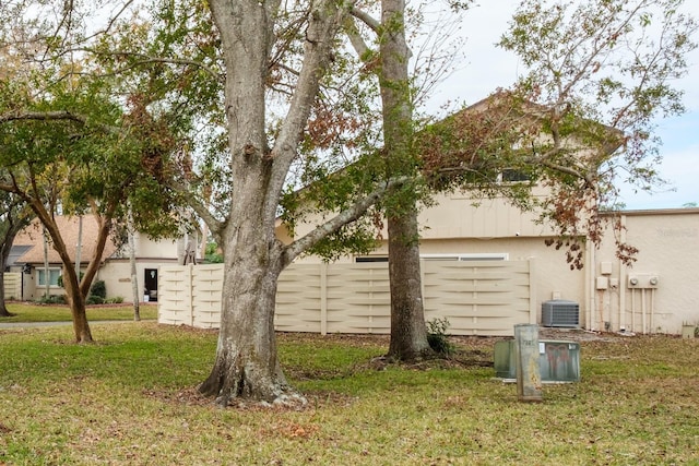 view of side of property with cooling unit and a lawn