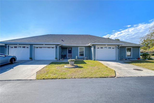 ranch-style house featuring a garage and a front lawn