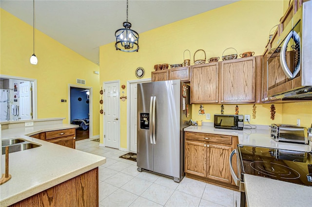 kitchen featuring decorative light fixtures, stainless steel appliances, an inviting chandelier, and light tile patterned floors