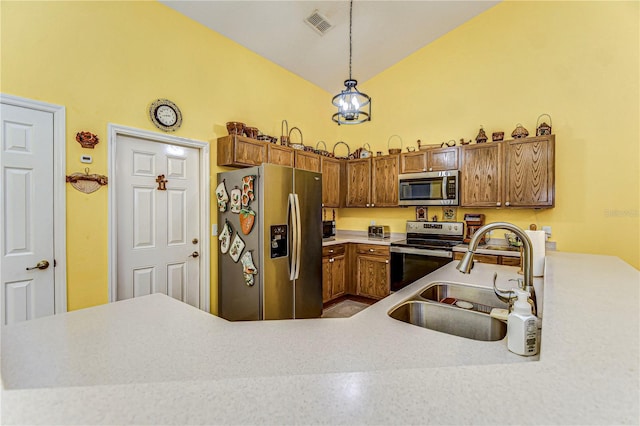 kitchen with stainless steel appliances, vaulted ceiling, sink, and pendant lighting