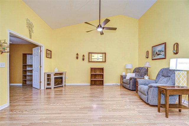 living area featuring ceiling fan, light hardwood / wood-style flooring, and high vaulted ceiling