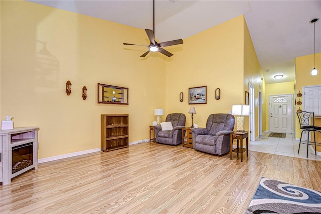 living room featuring high vaulted ceiling, light wood-type flooring, and ceiling fan