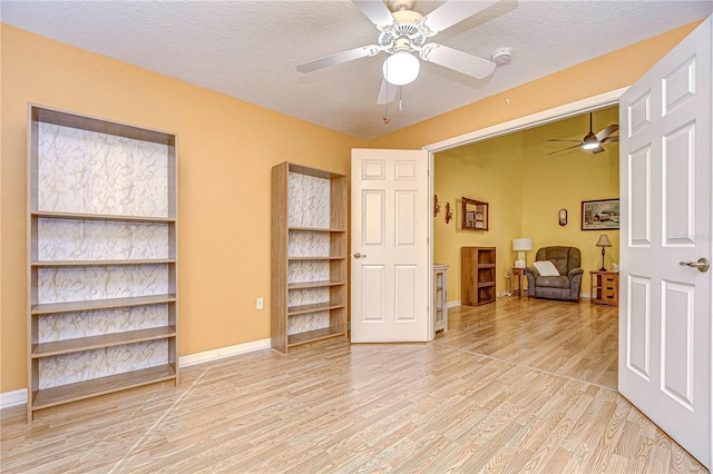 interior space featuring a textured ceiling, ceiling fan, and light hardwood / wood-style flooring