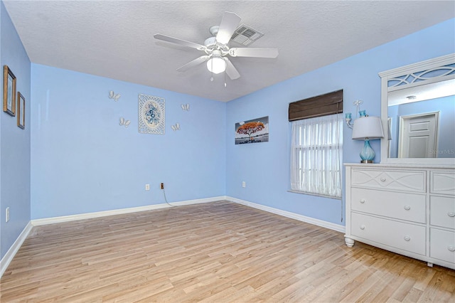 unfurnished bedroom featuring ceiling fan, light hardwood / wood-style floors, and a textured ceiling