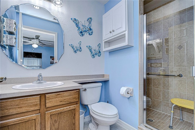 bathroom with toilet, an enclosed shower, vanity, and ceiling fan