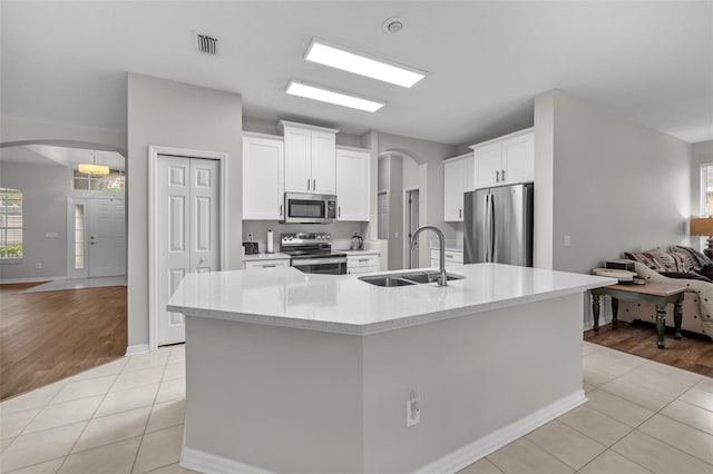 kitchen featuring sink, white cabinetry, light tile patterned floors, and stainless steel appliances