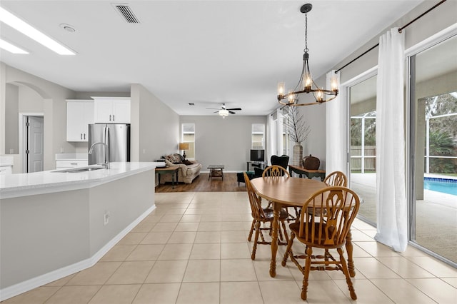 dining room featuring sink, ceiling fan with notable chandelier, and light tile patterned flooring