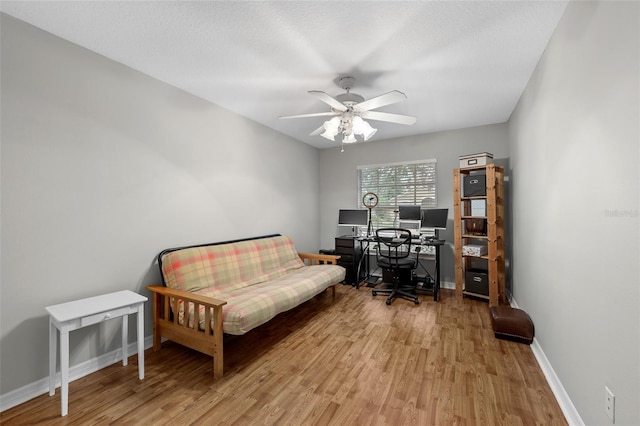 office area featuring ceiling fan, light wood-type flooring, and a textured ceiling