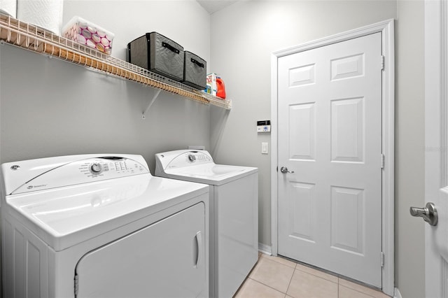 laundry room with washing machine and dryer and light tile patterned flooring