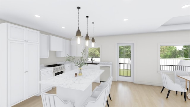 kitchen featuring sink, decorative light fixtures, white cabinetry, high end white range, and a kitchen island