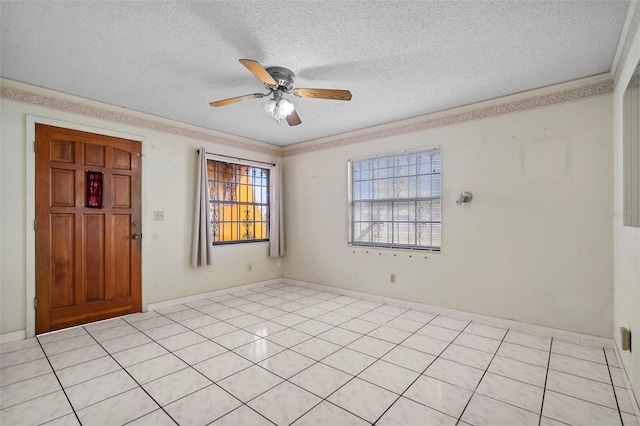 interior space featuring ceiling fan, a textured ceiling, ornamental molding, and light tile patterned flooring