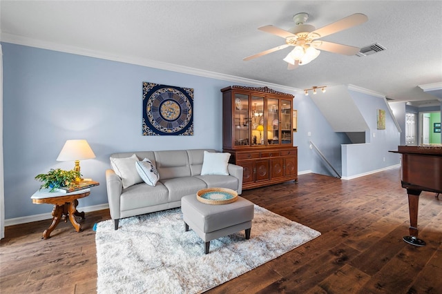 living room featuring ceiling fan, dark wood-type flooring, a textured ceiling, and crown molding