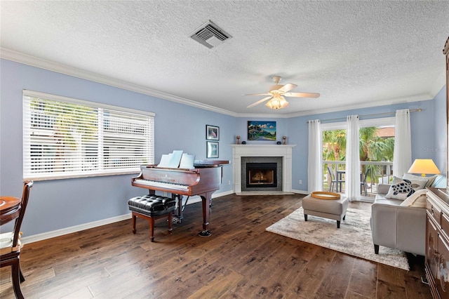 living room featuring a textured ceiling, ceiling fan, crown molding, and dark hardwood / wood-style floors