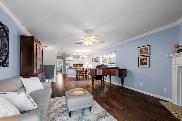 living room with ceiling fan with notable chandelier, a textured ceiling, a fireplace, dark hardwood / wood-style floors, and crown molding