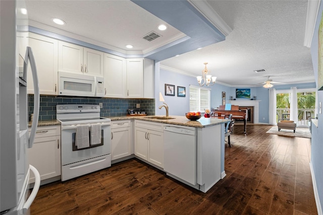 kitchen with white appliances, white cabinetry, sink, kitchen peninsula, and crown molding