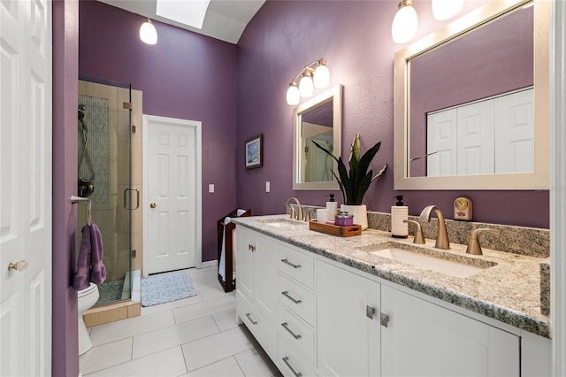 bathroom featuring tile patterned floors, toilet, a shower with door, and vanity