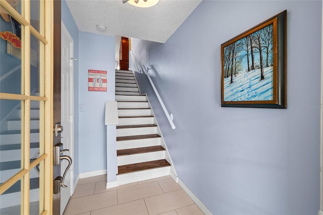 stairs featuring a textured ceiling