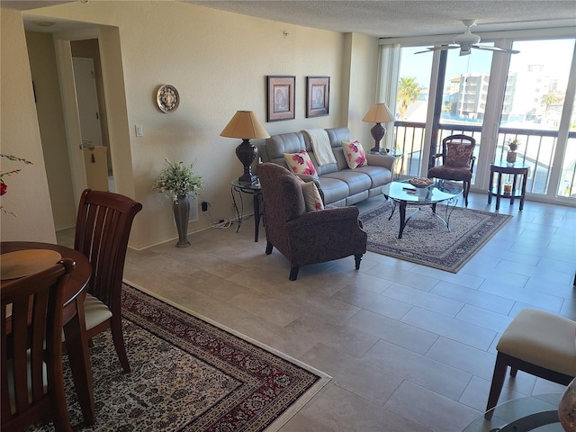 living room featuring a textured ceiling, ceiling fan, and floor to ceiling windows