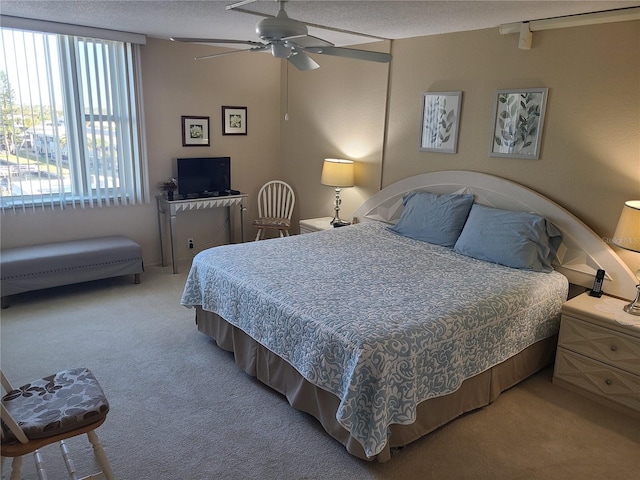 bedroom featuring ceiling fan, multiple windows, and carpet floors