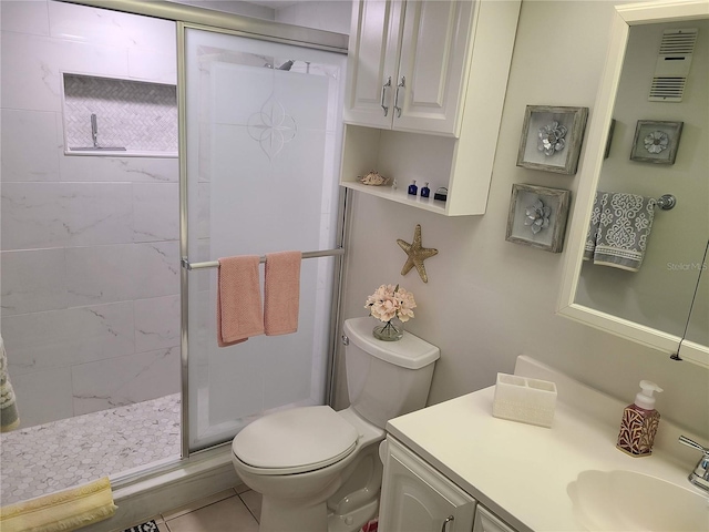 bathroom featuring toilet, tile patterned flooring, a shower with shower door, and vanity