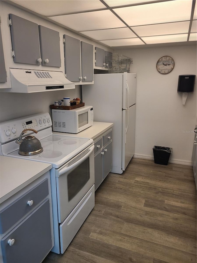 kitchen featuring dark wood-type flooring, white appliances, gray cabinetry, and a drop ceiling